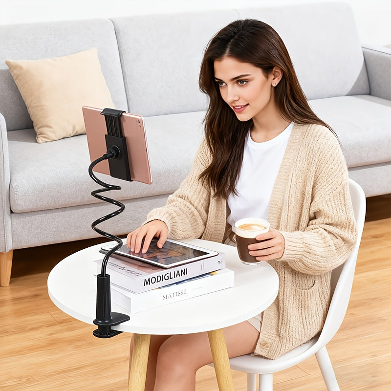 Black flexible hose tablet holder with clamp base, 360° adjustable, used by a woman at a white table.