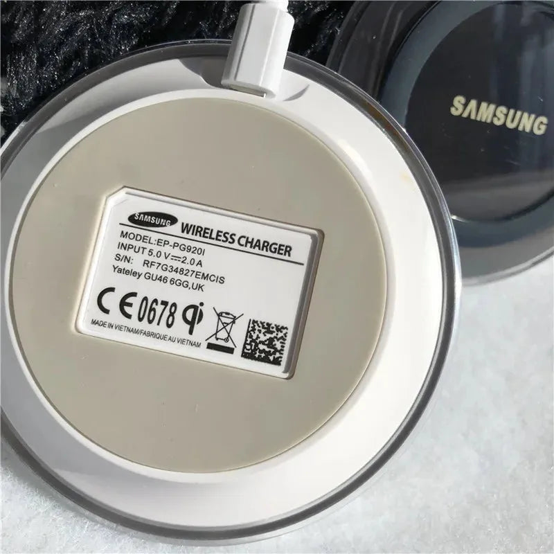 White circular Samsung EP-PG920I Qi wireless charging pad with connected micro USB cable.