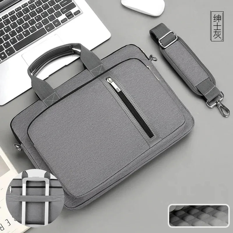 Unisex grey polyester laptop bag featuring top handles, a front zipper pocket, and a detachable padded shoulder strap.