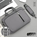 Unisex grey polyester laptop bag featuring top handles, a front zipper pocket, and a detachable padded shoulder strap.
