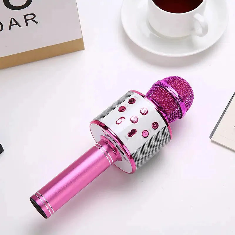Vibrant pink handheld wireless karaoke microphone with silver control panel and integrated Bluetooth speaker.