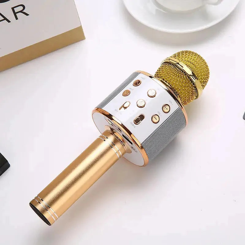 Gold and white wireless karaoke microphone with a metallic handle, multi-function control panel, and integrated Bluetooth speaker grilles.