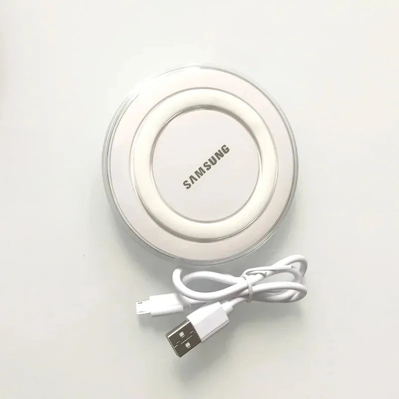 White Samsung Qi wireless charging pad, circular design with clear edge, shown with its coiled micro USB cable.